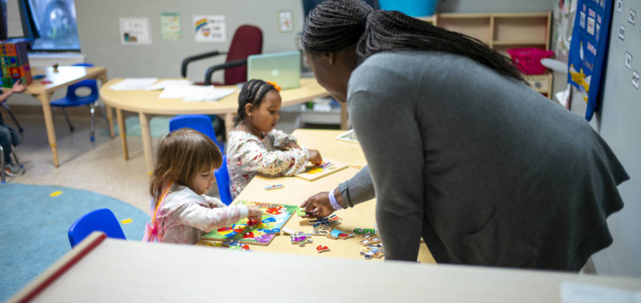 Instructor helping two girls with puzzles